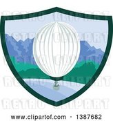 Vector Clip Art of Retro Hot Air Balloon over Mountains and the Ocean in a Shield by Patrimonio